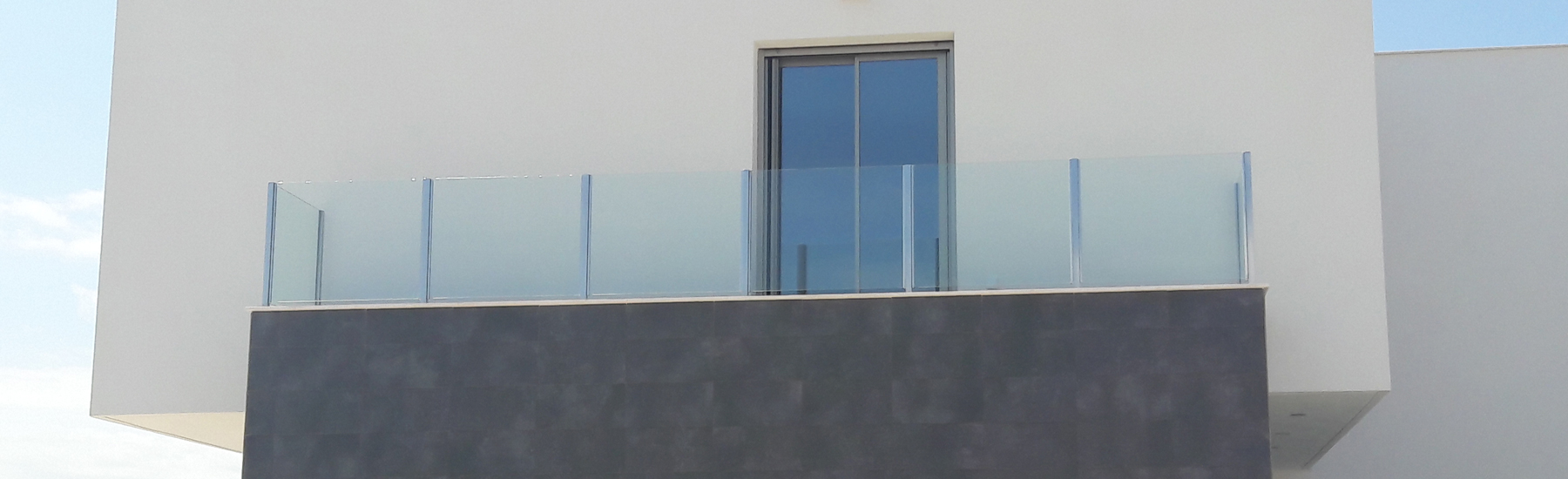 Barandilla perimetral de vidrio y puerta de acceso a terraza de aluminio Technal serie Soleal