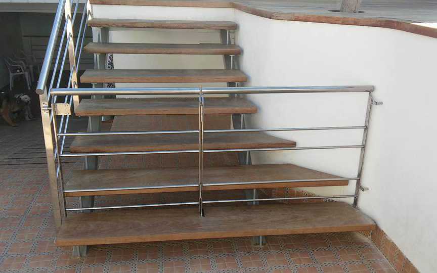 Barandilla de acero inoxidable junto a puerta de protección de escalera